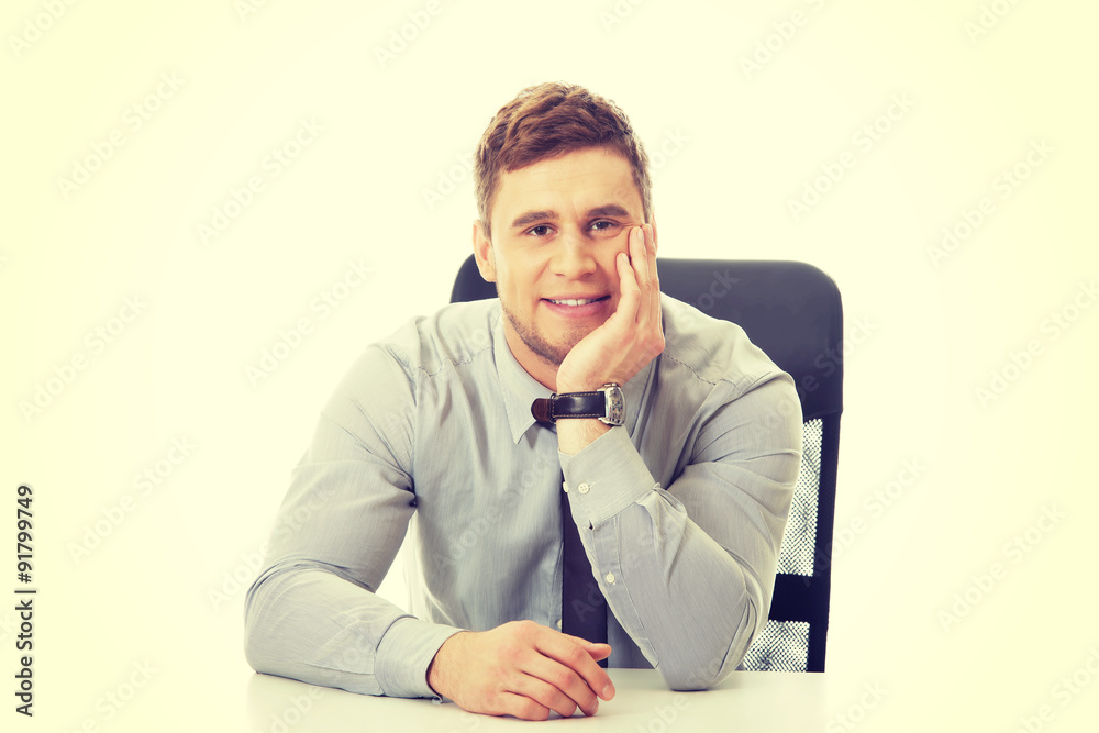 Businessman sitting by a desk in the office. Businessman sitting by a desk in the office.
