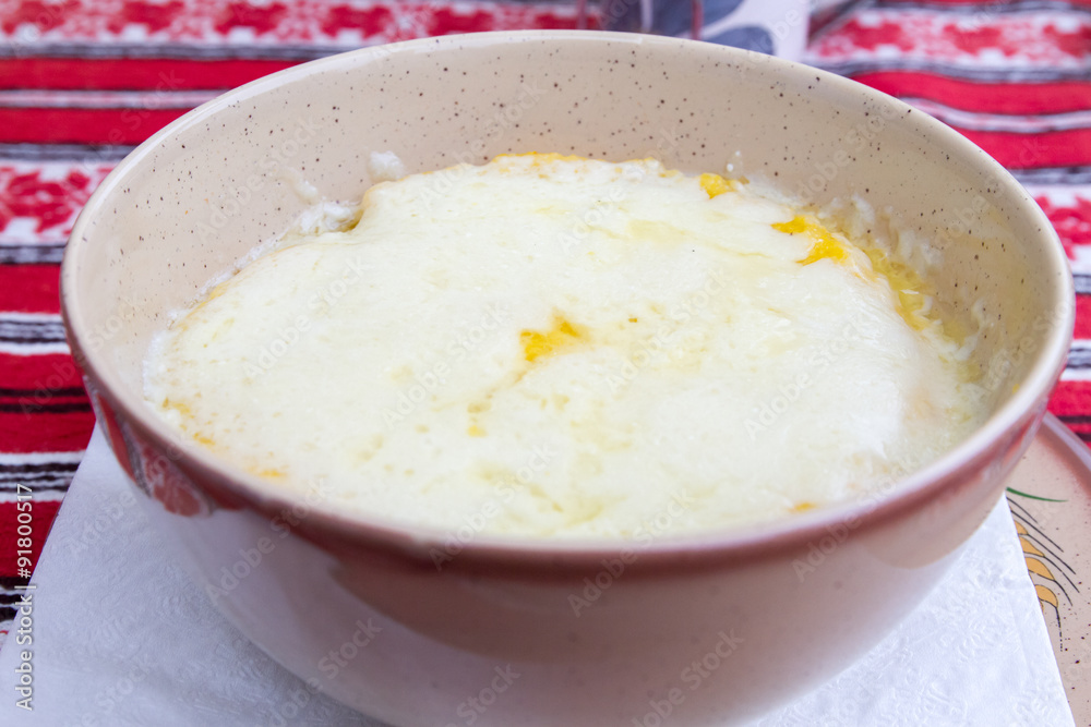 Romanian traditional plate of cheese and polenta over traditional, rural tablecloths Romanian traditional plate of cheese and polenta over traditional, rural tablecloths