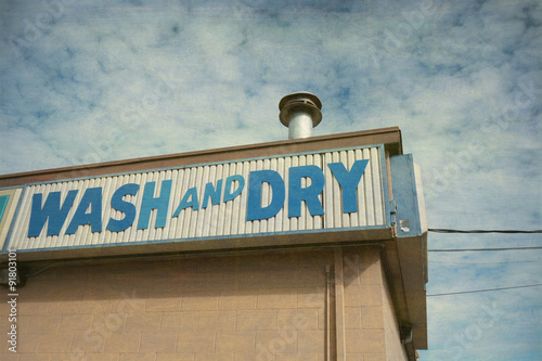 Fotografija aged and worn vintage photo of wash and dry laundromat sign
