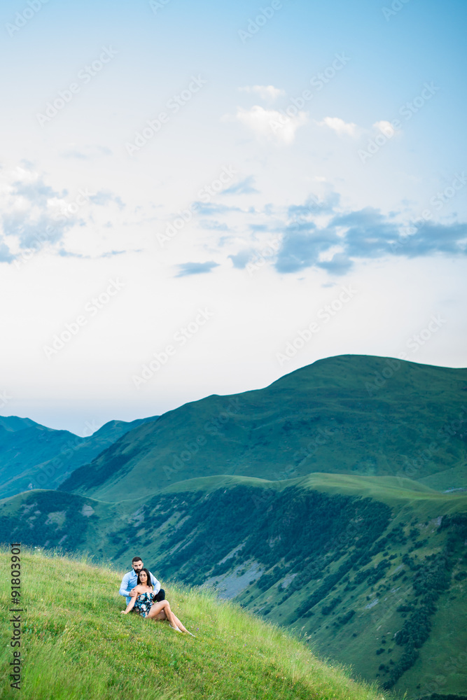 beautiful couple lying in a meadow in the mountains in spring