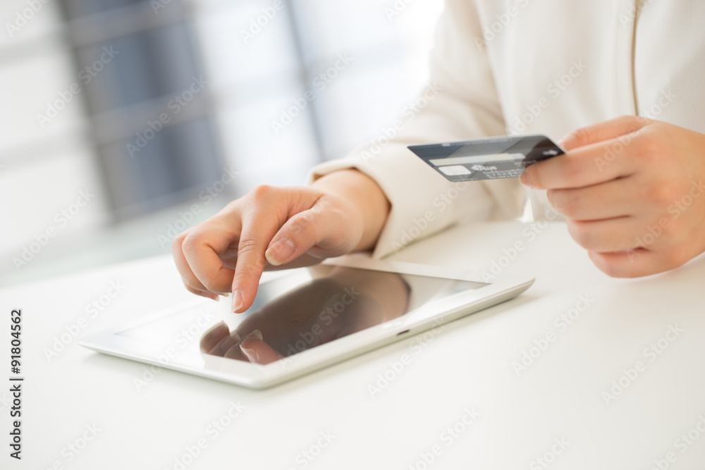 Fototapeta premium Hands of an office woman typing keyboard with credit card