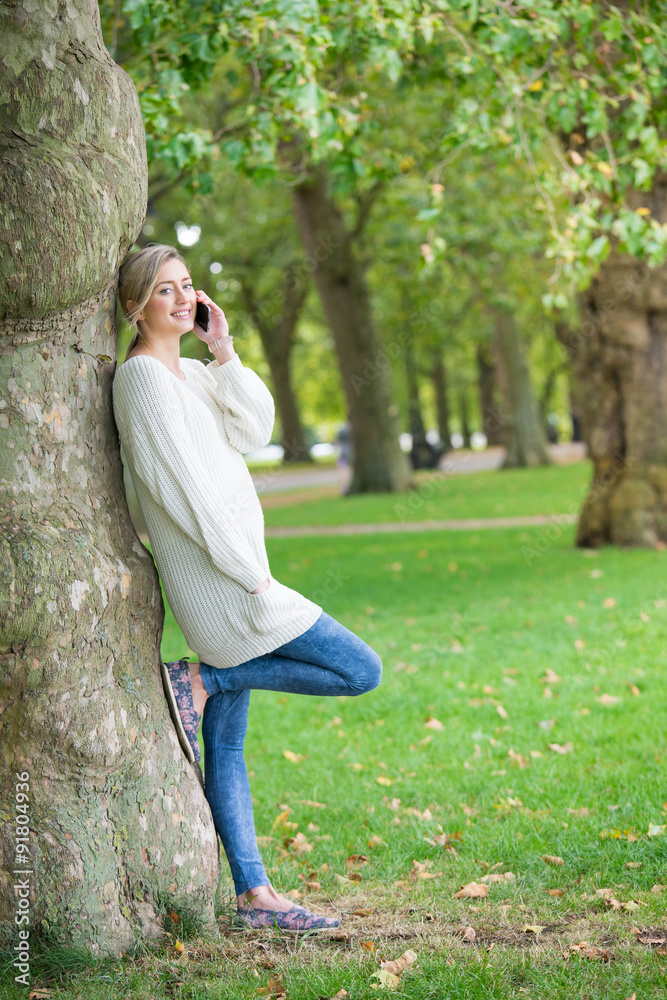 Young woman using tablet & mobile phone in the park Young woman using tablet & mobile phone in the park