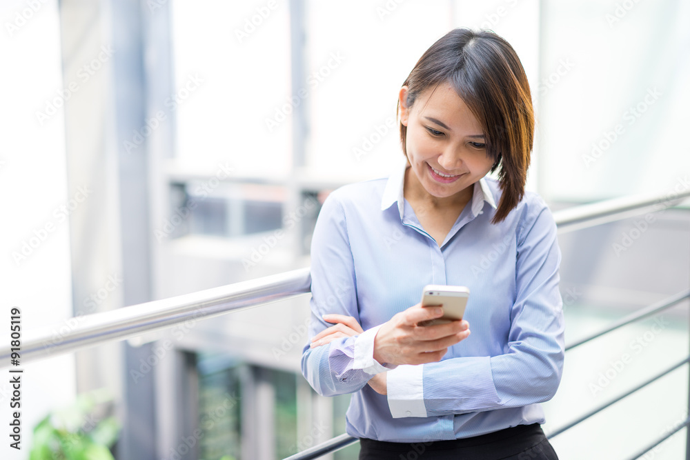 Asian businesswoman talking on a mobile phone at the office Asian businesswoman talking on a mobile phone at the office