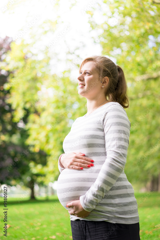 Happy and young pregnant woman in park in summer Happy and young pregnant woman in park in summer