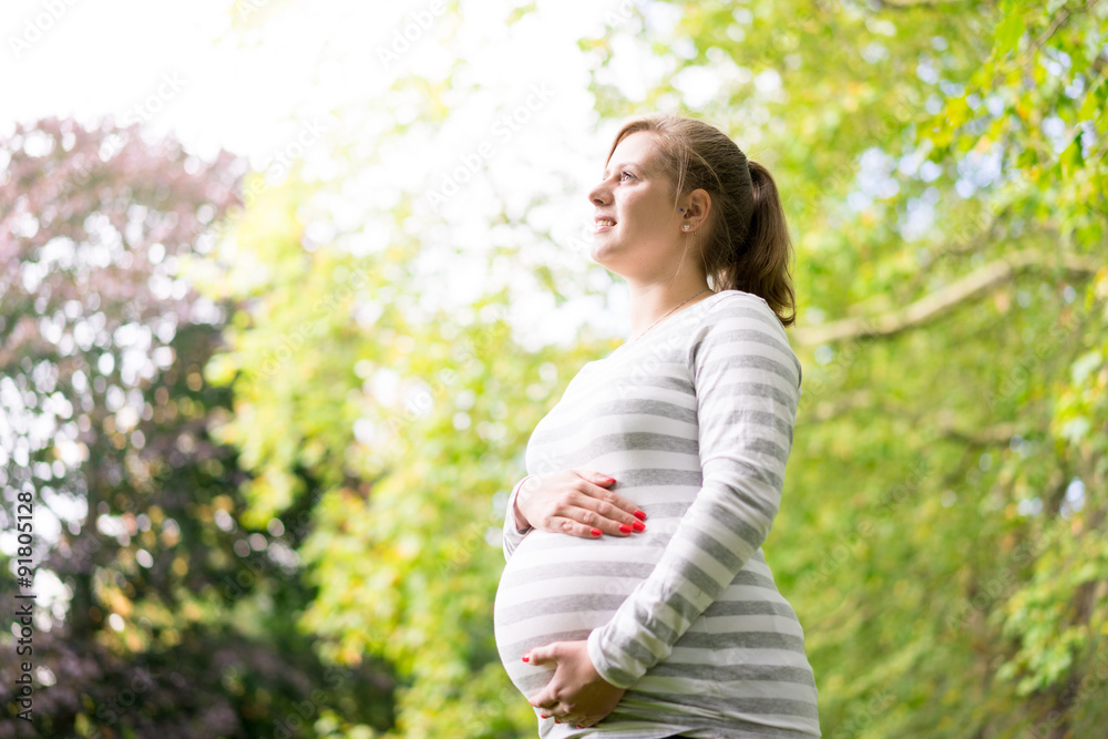 Happy and young pregnant woman in park in summer Happy and young pregnant woman in park in summer