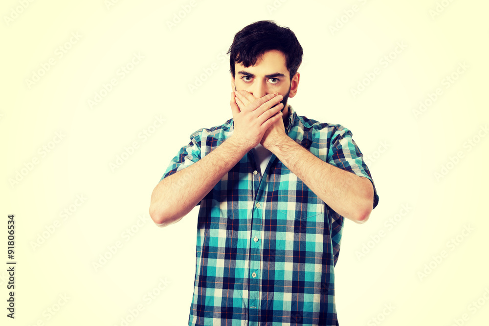 Young shocked man covering his mouth. Young shocked man covering his mouth.