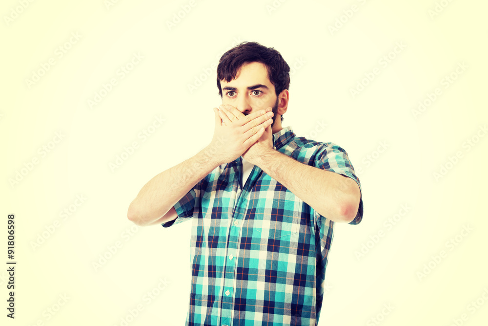 Young shocked man covering his mouth. Young shocked man covering his mouth.