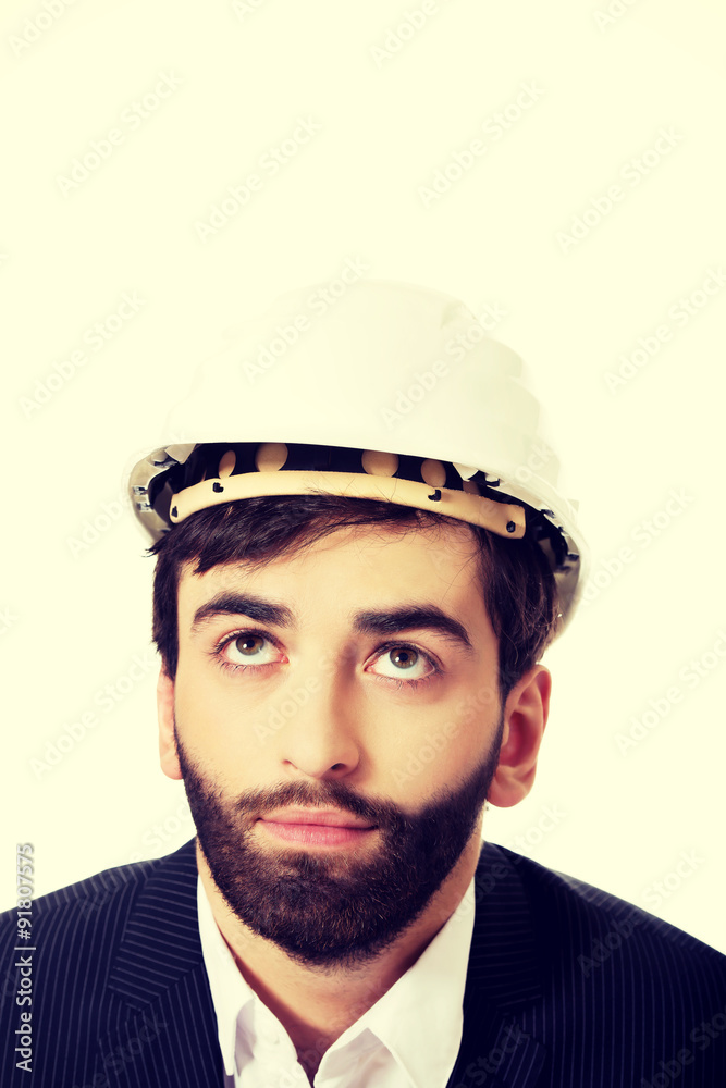 Young man with hard hat looking up. Young man with hard hat looking up.
