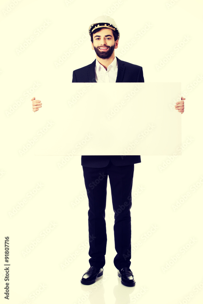 Handsome engineer in helmet holding empty banner. Handsome engineer in helmet holding empty banner.