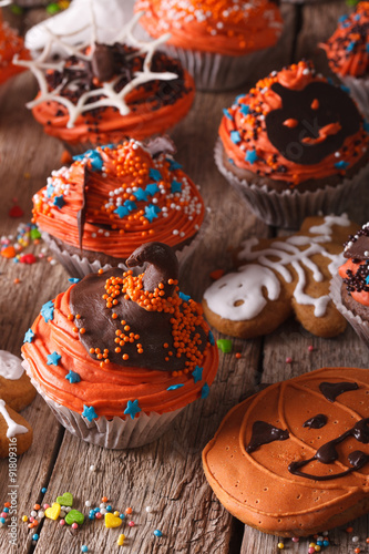 Halloween cupcakes and gingerbread cookies close-up. vertical 