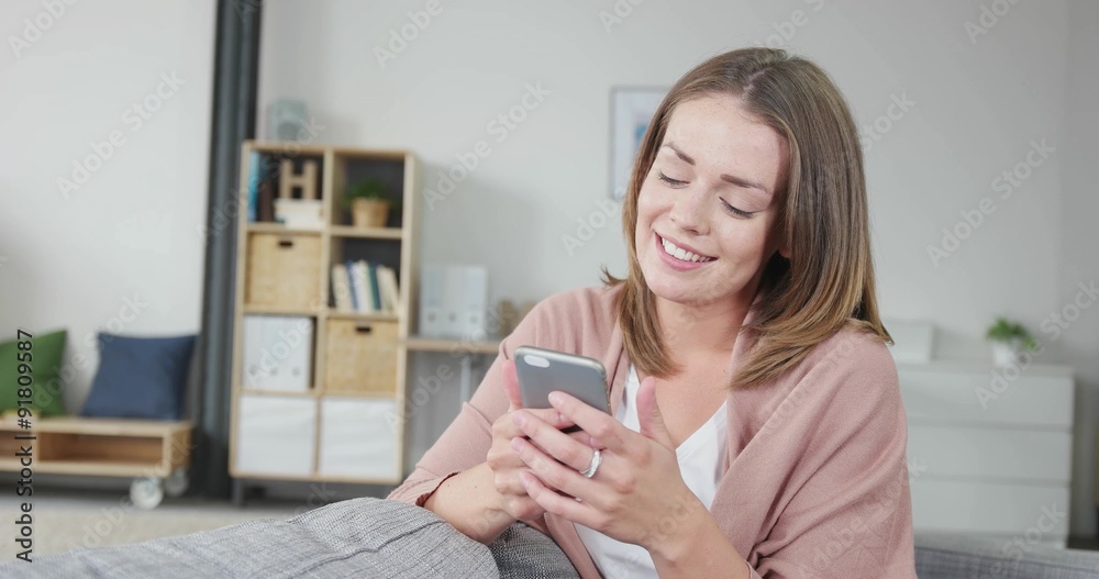 attraktive frau sitzt auf dem sofa und tippt eine nachricht auf ihrem smartphone attraktive frau sitzt auf dem sofa und tippt eine nachricht auf ihrem smartphone