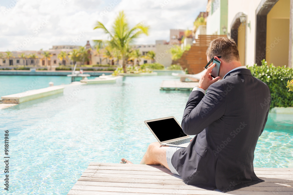 Businessman working by the pool