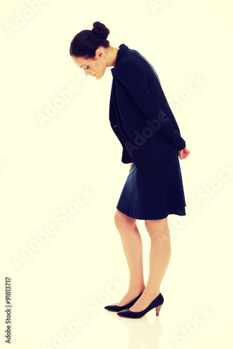 Young business woman bending down.