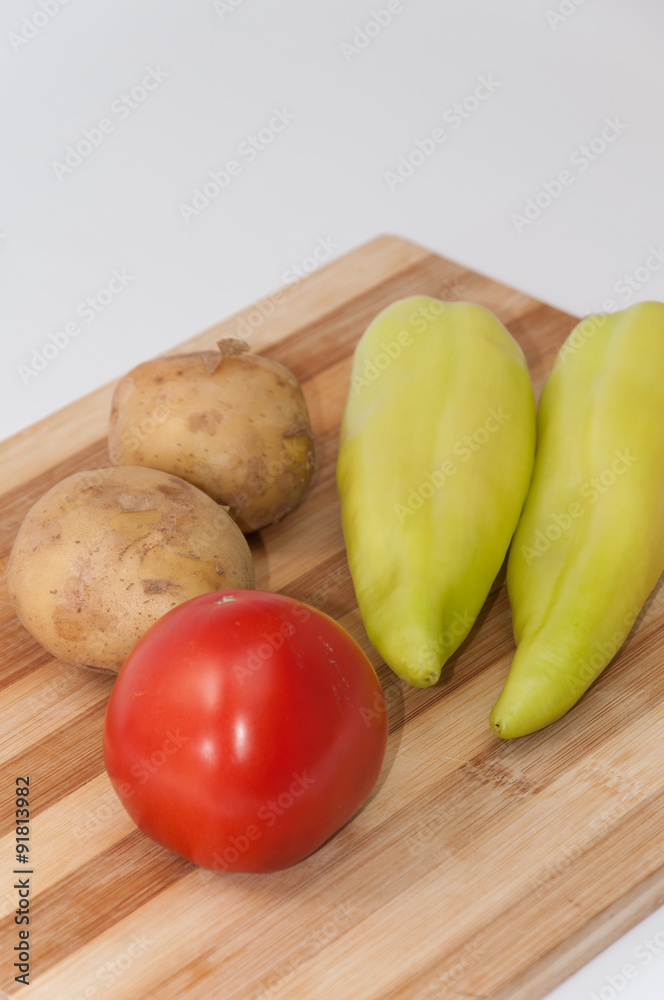 Tomato potato and green paprika on the wooden board Tomato potato and green paprika on the wooden board