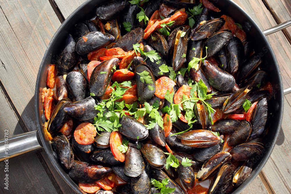 Mussels with chorizo cooking in a pan Mussels with chorizo cooking in a pan