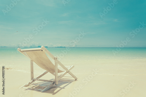 beach chair on beach with blue sky - soft focus with film filter © topntp