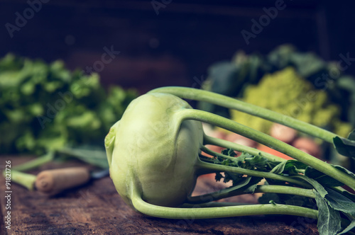 Fresh organic kohlrabi on rustic kitchen table with garden vegetables 