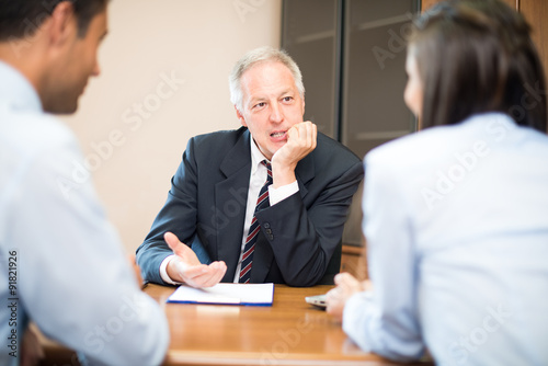 Businessman talking to a couple photo