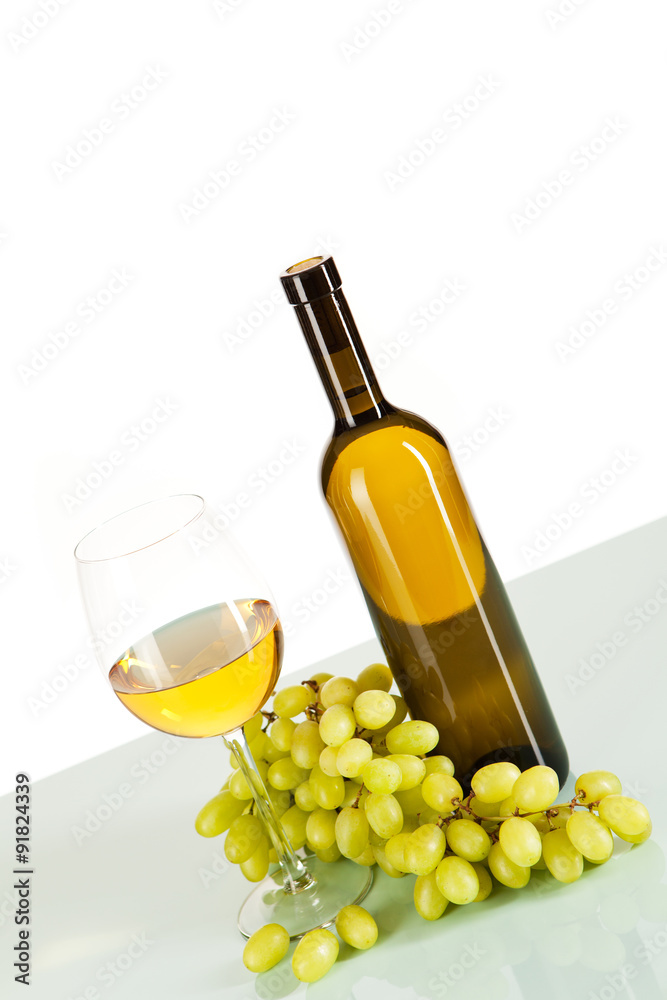Weißwein im Glas und in der Flasche mit Weintrauben