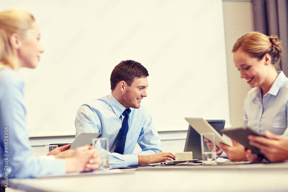 smiling business people with tablet pc in office