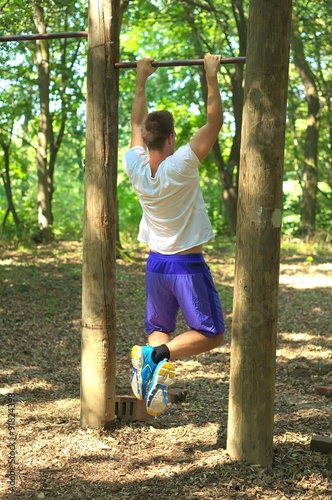 Man practice fitness in forest.