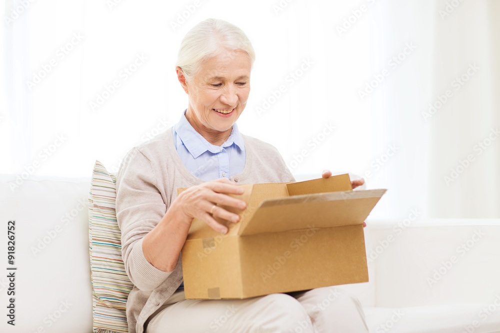 happy senior woman with parcel box at home