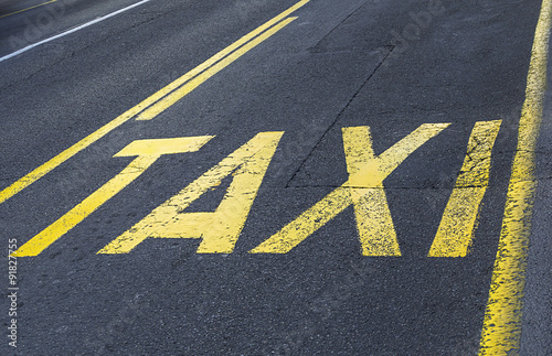 Yellow road sign on asphalt - taxi sign.