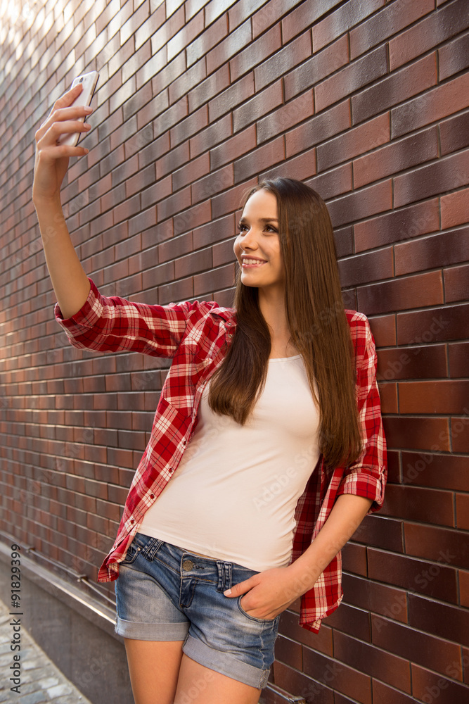 Obraz premium Girl making selfie photo and shwing her tongue