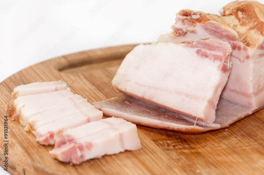 Slices of smoked bacon on the kitchen cutting board Slices of smoked bacon on the kitchen cutting board
