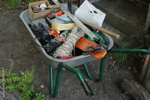 A stack of working tools in wheelbarrow