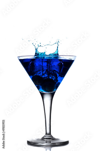 Blue cocktail splash in martini glass