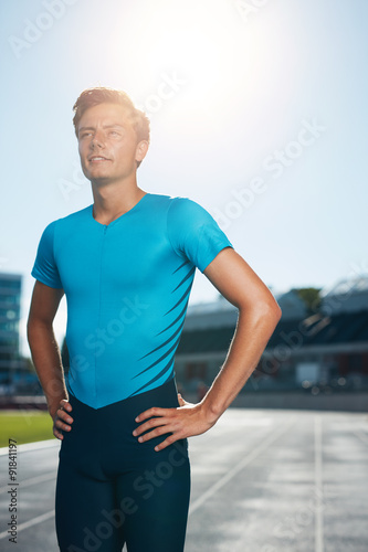 Sprinter stands in athletics stadium