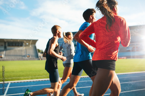 Fototapeta Naklejka Na Ścianę i Meble -  Young athletes running on race track in stadium