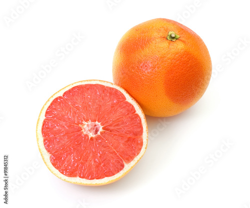 half and whole grapefruits on white background
