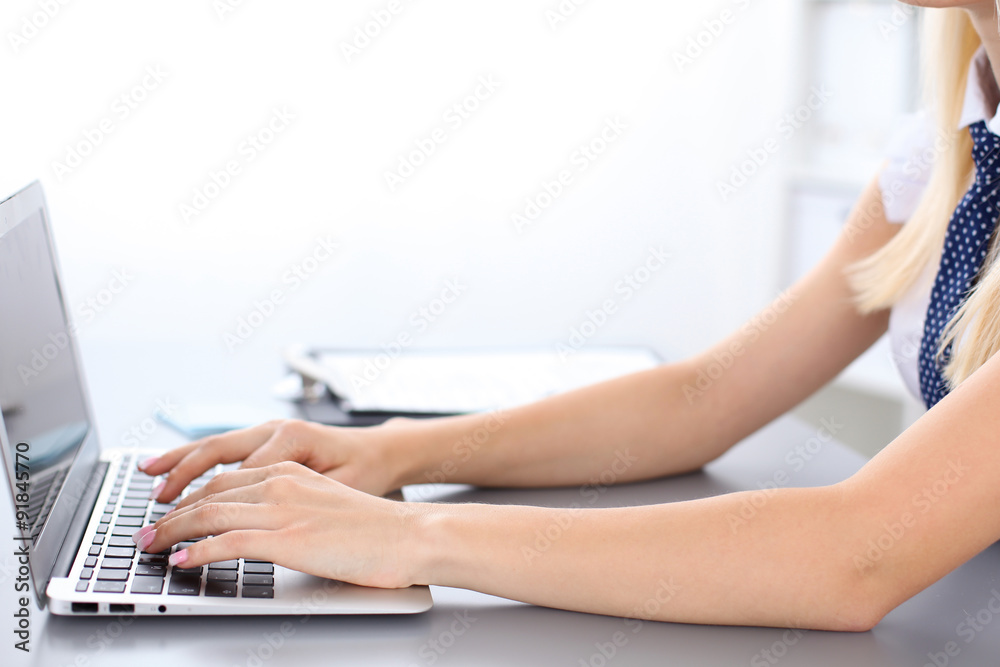 Fototapeta premium Close up of business woman hands typing on laptop computer, blue tie with polka dots