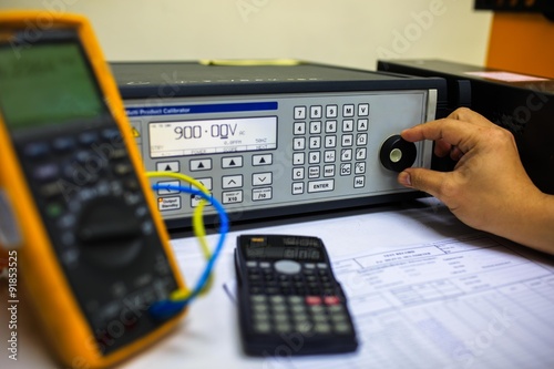 Technician turn switch of  precision multi calibrator for calibration multimeter photo