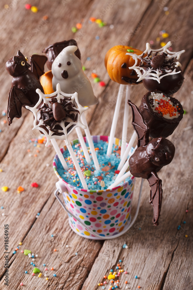 Halloween cake pop decorated with icing on the table. vertical
