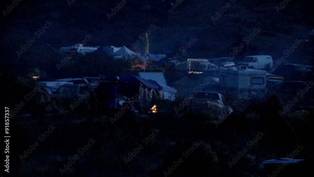 People have bonfires going at a campground. People have bonfires going at a campground.