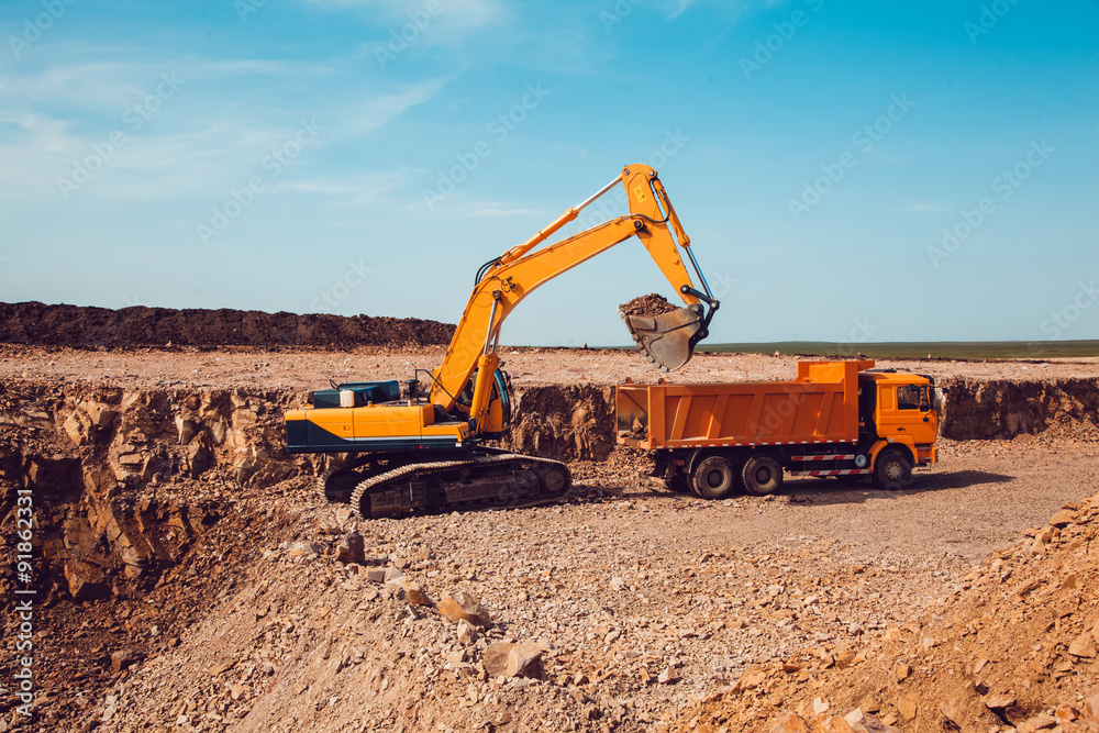 Excavator Loads Gravel into a Truck on a Crushed Stone Quarry