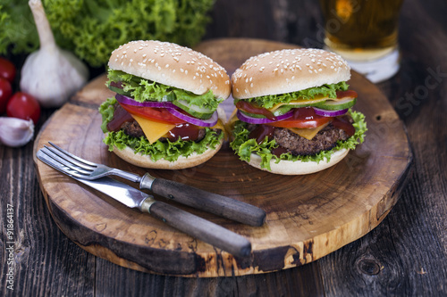 Beef burgers on a wooden board with aromatic spices