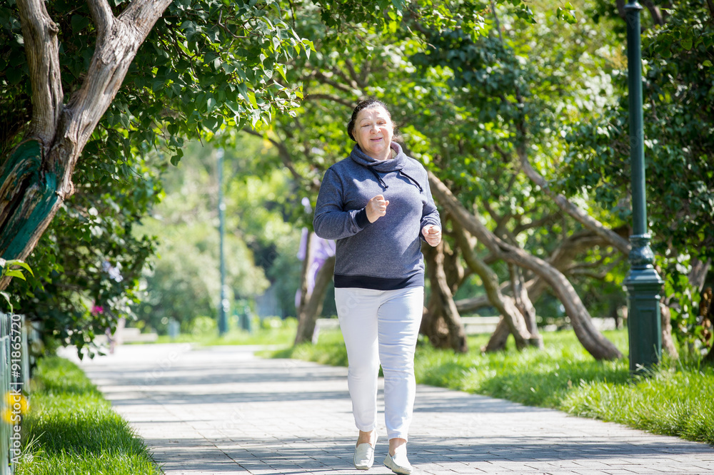 Mature woman jogging in the park. Healthy lifestyle Mature woman jogging in the park. Healthy lifestyle