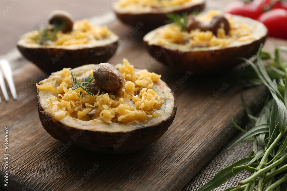 Baked potatoes with cheese and mushrooms on table close up