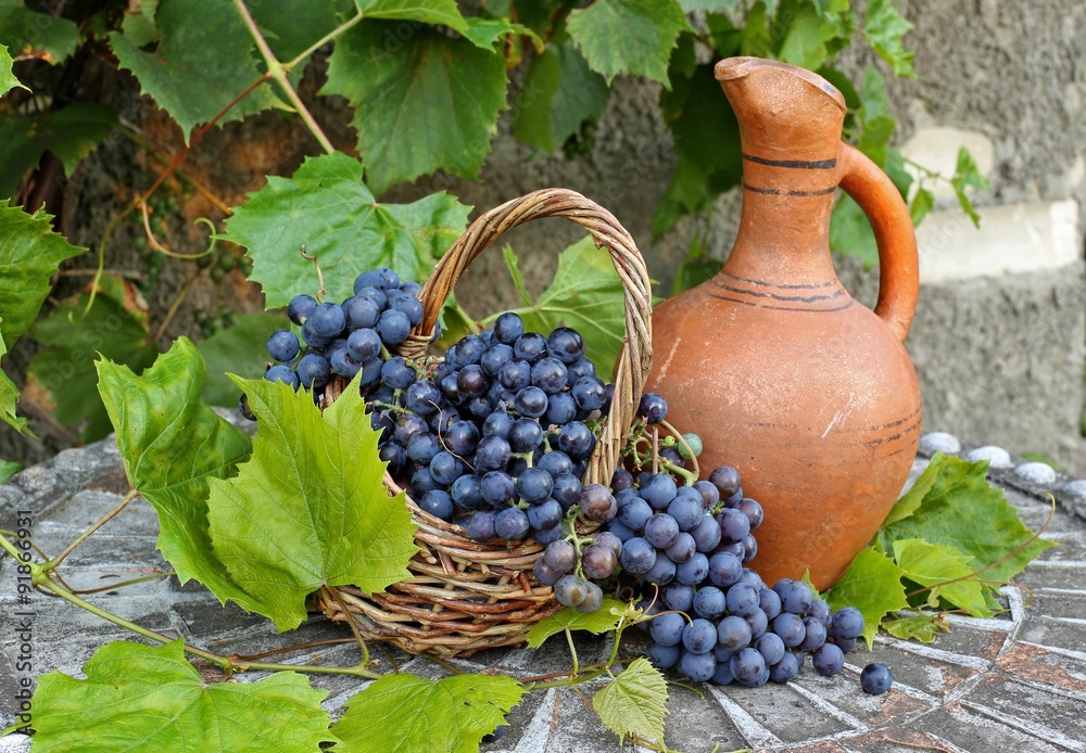 Naklejka Basket with grapes and ceramic jug