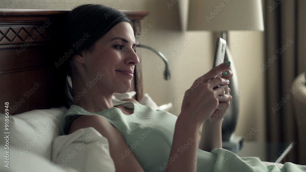 Young businesswoman using smartphone lying on bed in hotel room
Young businesswoman using smartphone lying on bed in hotel room