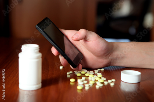 Person with Cellphone and Pills