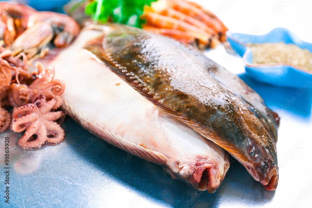 Fresh fishes and shrimps with spices on metal background Fresh fishes and shrimps with spices on metal background