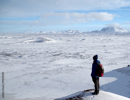 Mann genießt Aussicht auf einem Berg in Island im Winter