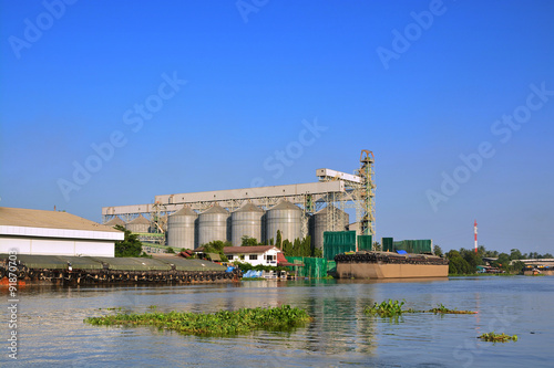 Agriculture Silo of Vegetalbe Oil plant beside the river photo