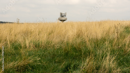 Tableau sur toile Top of the water tank with radio transmitters in the grass field