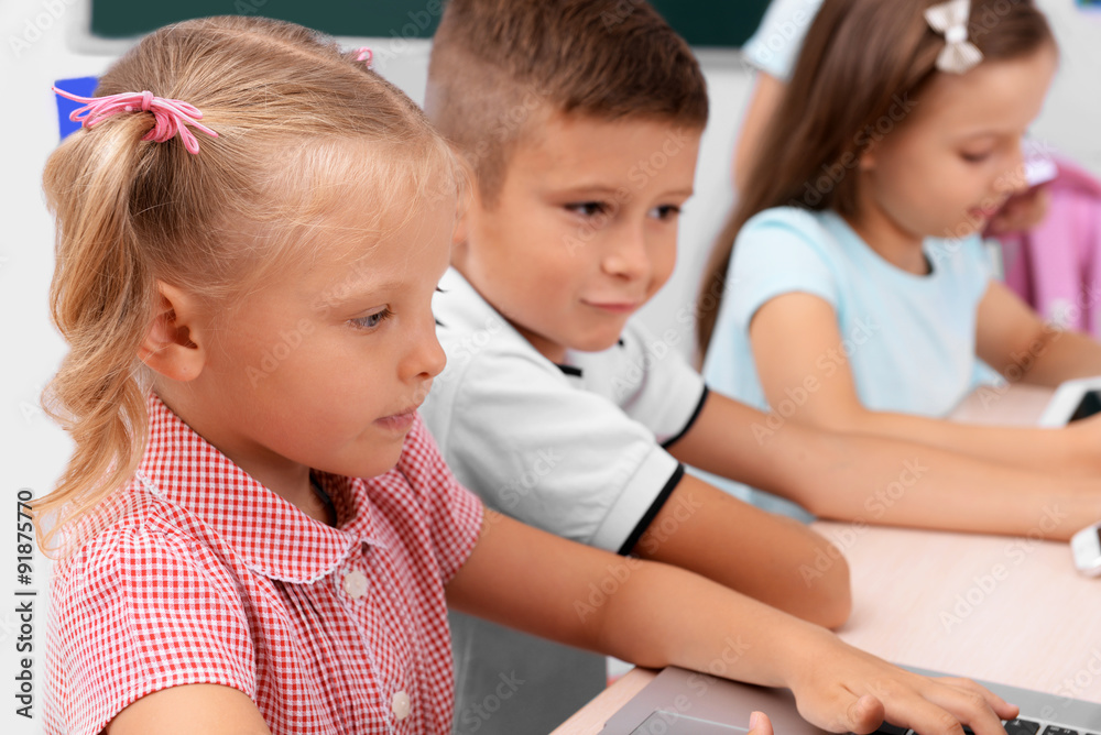 Group of children at laptop in the classroom Group of children at laptop in the classroom